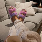 Moment cocooning sur le canapé avec pantoufles violettes en fausse fourrure douce et moelleuse Ambage.
